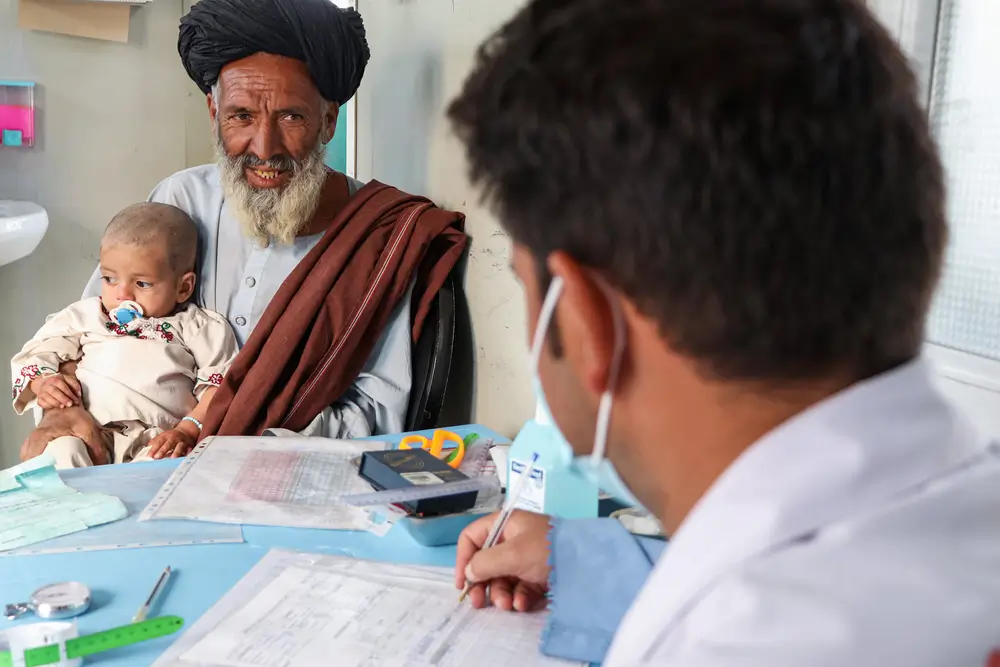 Khaista Gul y su nieto Mustafa de 2 años, quien tiene desnutrición, durante una consulta en el Centro de Alimentación Terapéutica Ambulatoria de MSF en Kandahar, Afganistán.