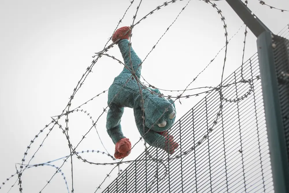 Juguete detenido en alambre de púas que limita el movimiento delas personas migrantes en Calais, Francia