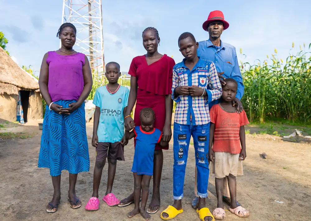 Día mundial de la salud mental: Nyamal Simon, (vestido de rojo), posa para una foto familiar en su casa de Lankien, en el estado de Jonglei, Sudán del Sur. Recibe atención de salud mental de Médicos Sin Fronteras.