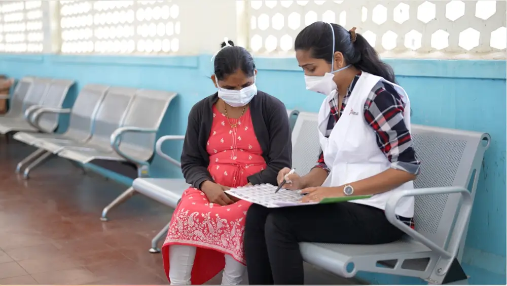 Personal de MSF explica a paciente con tuberculosis resistente a los medicamentos sobre el tratamiento que debe seguir.