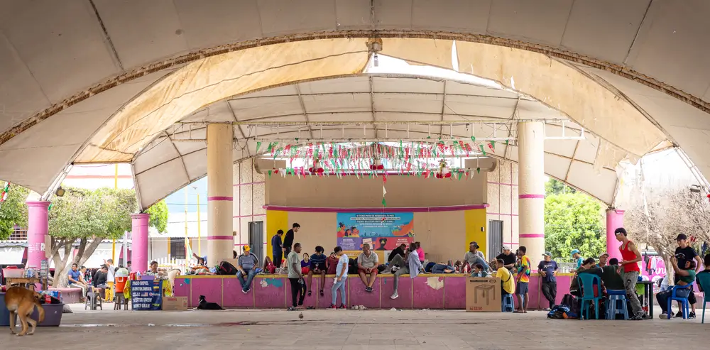 Personas migrantes que acaban de cruzar desde Guatemala esperan en un parque de Suchiate, en el sur de México, antes de continuar su viaje hacia el norte.