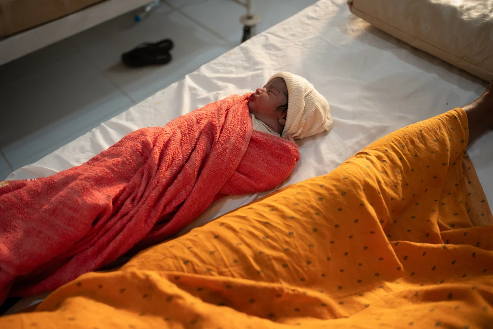 Un recién nacido duerme junto a su madre antes de que le den el alta de la maternidad en Mocha, Yemen, seis horas después del parto.