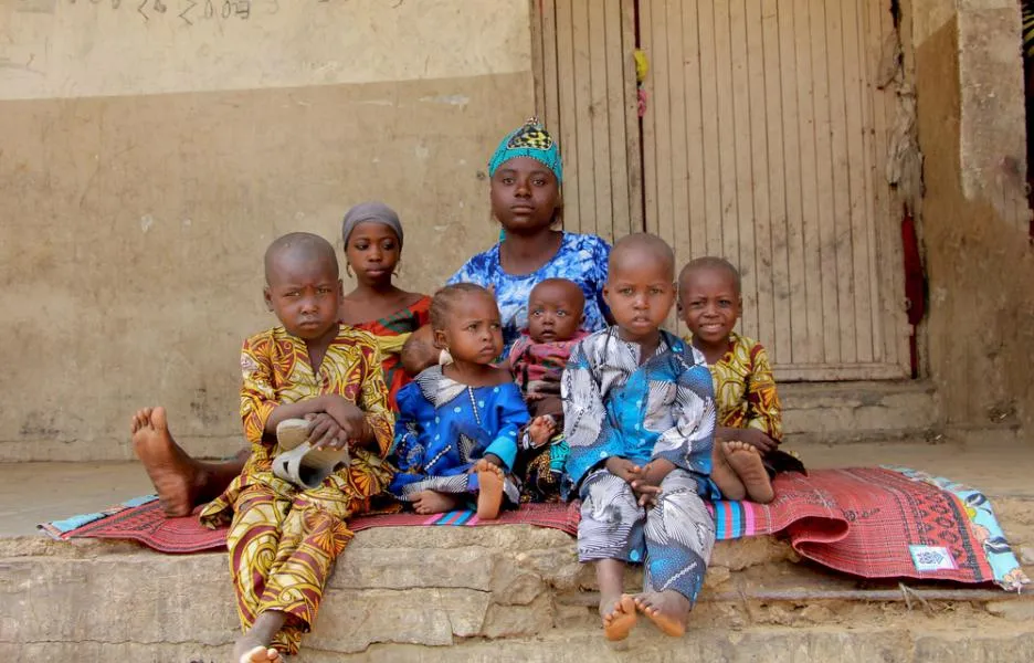 Rukkaya Mohammed*, sentada en una esterilla con sus hijos en un campo de desplazados internos en el área de gobierno local de Zurmi.
