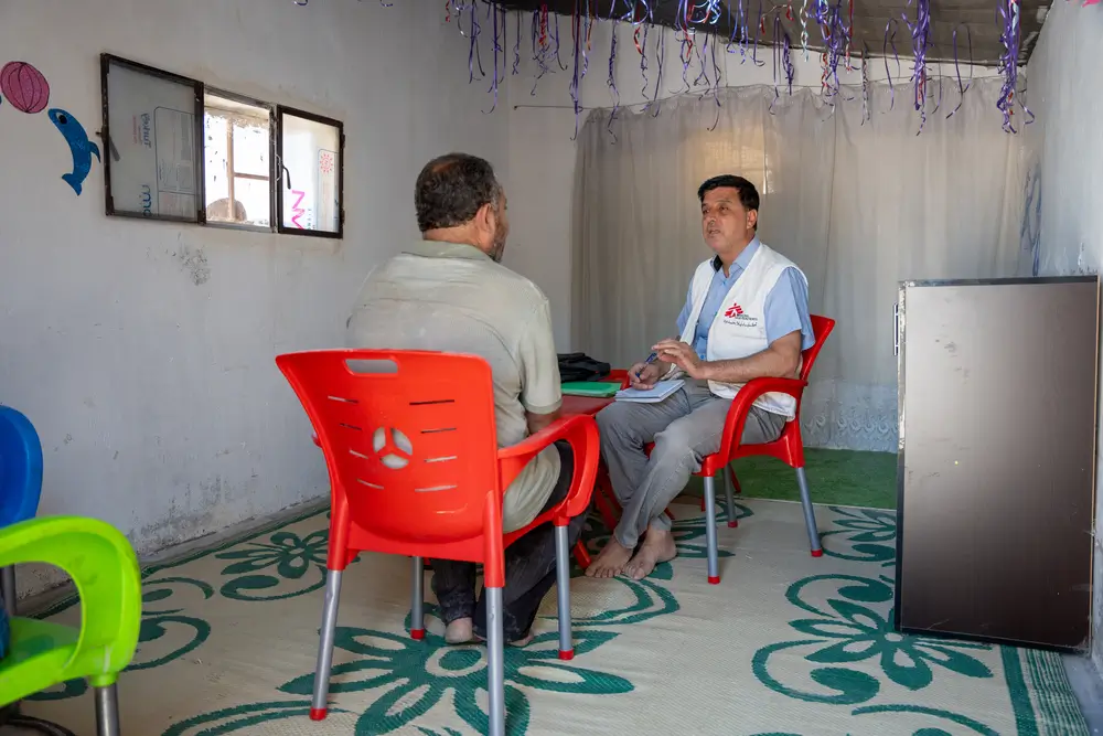Mohammad, consejero de salud mental de MSF en el noroeste de Siria, lleva a cabo una sesión de salud mental con un paciente que experimenta problemas psicológicos (heridas invisibles) en una de las clínicas móviles de MSF en los campamentos de Dair Hassan.