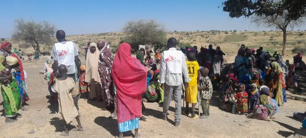 Familias en Rokero, Sudán, esperan que el equipo instale el punto de vacunación para vacunar a sus hijos contra el sarampión.