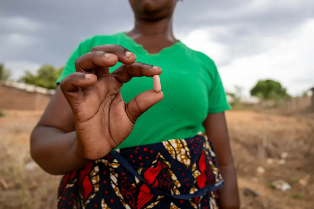 Una mujer con VIH, paciente de MSF en Mozambique, mostrando uno de sus medicamentos. © Martim Gray Pereira/MSF