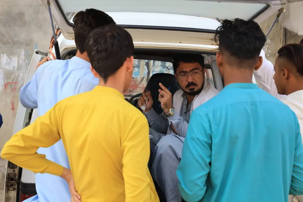 Durante una clínica móvil en Machar Colony, Karachi, el enfermero de MSF Aman Ullah explica más sobre los síntomas de la hepatitis C, cómo afecta a las personas y qué medidas se pueden tomar para prevenirla, Pakistán, noviembre de 2023.