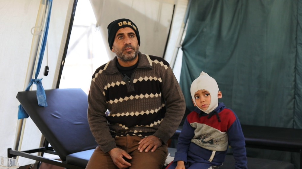 Ali Al Farra sentado junto a su hijo Mohammad Ali al Fara, de 3 años.