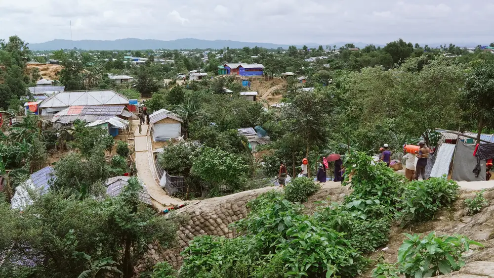 Los rohinyá regresan a sus refugios a pie, cargando provisiones desde un punto de distribución. El acceso a la atención médica se realiza principalmente a pie y en transporte público, con acceso limitado a vehículos de emergencia.