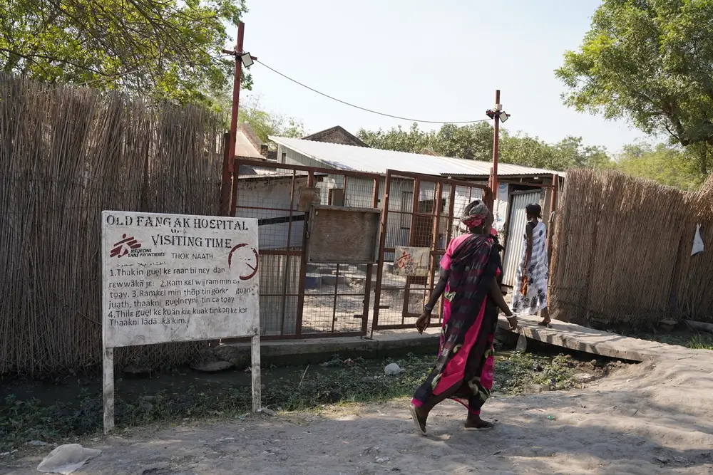 Una mujer camina frente a la entrada del hospital de MSF en Old Fangak, estado de Jonglei.