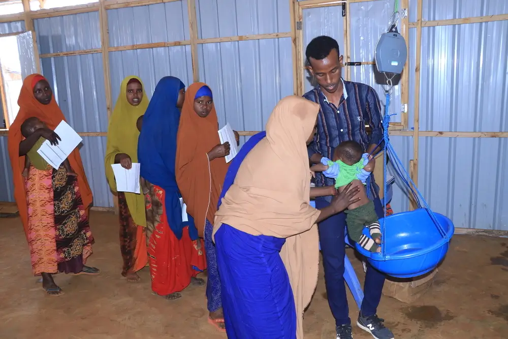 El impacto de la falta de financiación en la desnutrición en Somalia. Las madres hacen fila para pesar a sus hijos en un centro de atención descentralizado apoyado por MSF cerca del campo de desplazados internos de Afmadow.