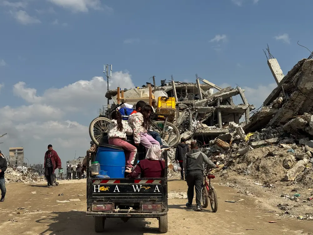 Familia palestina desplazada montada en un tuktuk; regresando para establecerse en la ciudad de Beit Lahia, al norte de la Franja de Gaza.