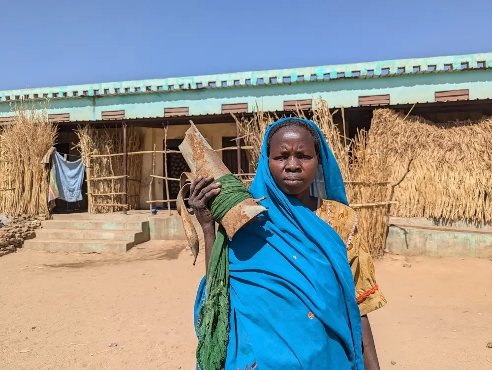 Dos años de guerra en Sudán: Fátima Mohamed sostiene los restos de un proyectil que impactó en su casa, destruyéndola y matando a su hermano y a su sobrino.
