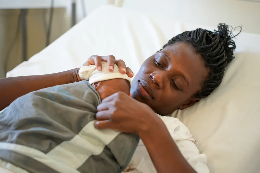 Una madre practica el método canguro con su bebé prematuro. Este método piel con piel promueve el crecimiento físico del recién nacido, estabiliza su temperatura corporal y fortalece el vínculo entre madre e hijo.