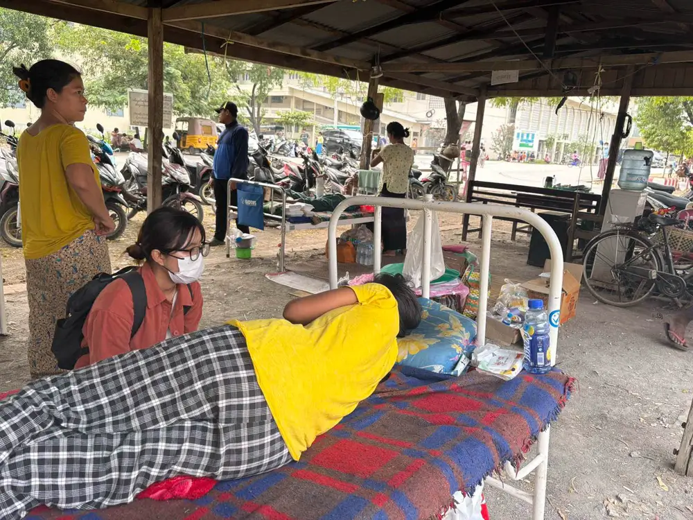 Un voluntario brinda primeros auxilios psicológicos a un paciente ingresado tras el terremoto en el Hospital Universitario de Mandalay.
