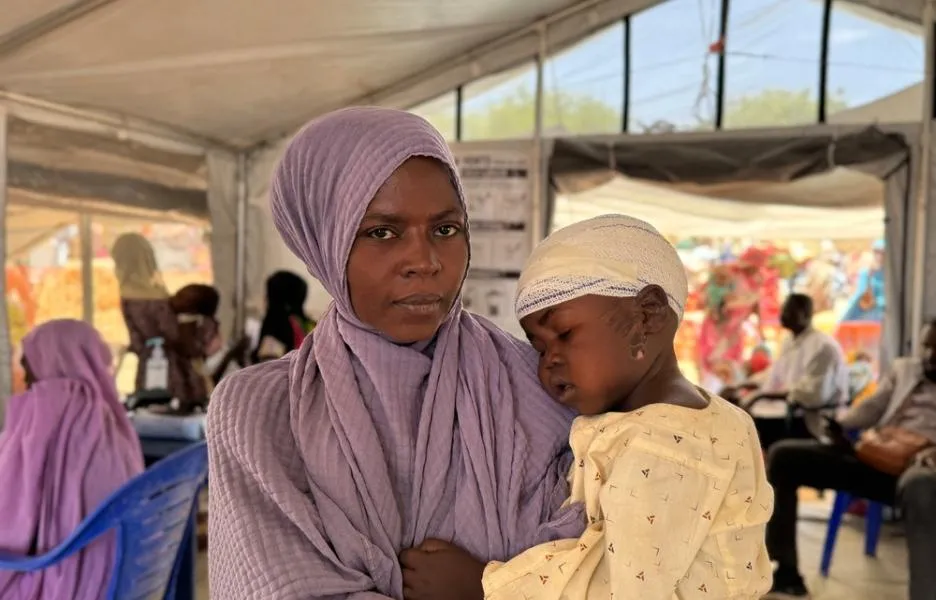 Mariam sostiene a Adam en brazos, en el puesto de salud de MSF en Tawila Umda. Adam fue herido en la cabeza por una bala cuando él y su familia intentaban huir del campo de Zamzam.Es uno de los 138 niños tratados por MSF por heridas de bala desde el 11 de abril.