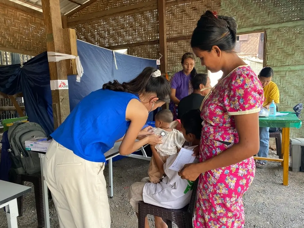 La doctora Zar Lin Aung revisa los pulmones de Kaung Pyae Khant (4 meses), que tiene tos. Su hermano, Kaung Pyae Kyaw (13), lo sostiene en brazos, mientras su madre, Zin Mar Win (30), permanece cerca.