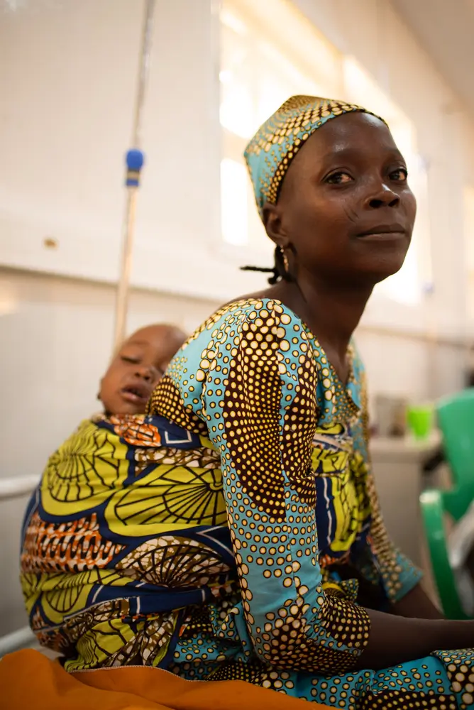La bebé Jamila está recibiendo tratamiento por desnutrición en el centro de alimentación para pacientes hospitalizados apoyado por MSF en la ciudad de Katsina, mientras es atendida por su madre, Rabi.