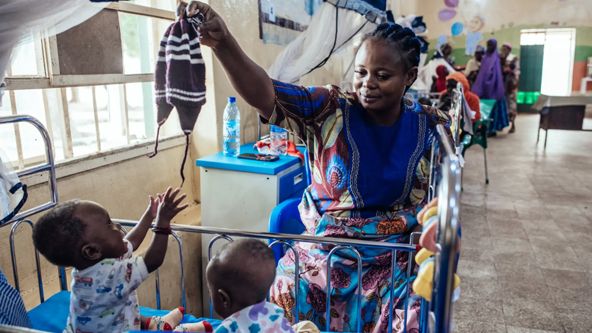 Amaka Joseph, de 35 años, juega con sus hijos, John y Jerry, de 11 meses, en recuperación, en un centro de ITFC del Hospital Especializado de Sokoto, Nigeria, el viernes 22 de julio de 2022.