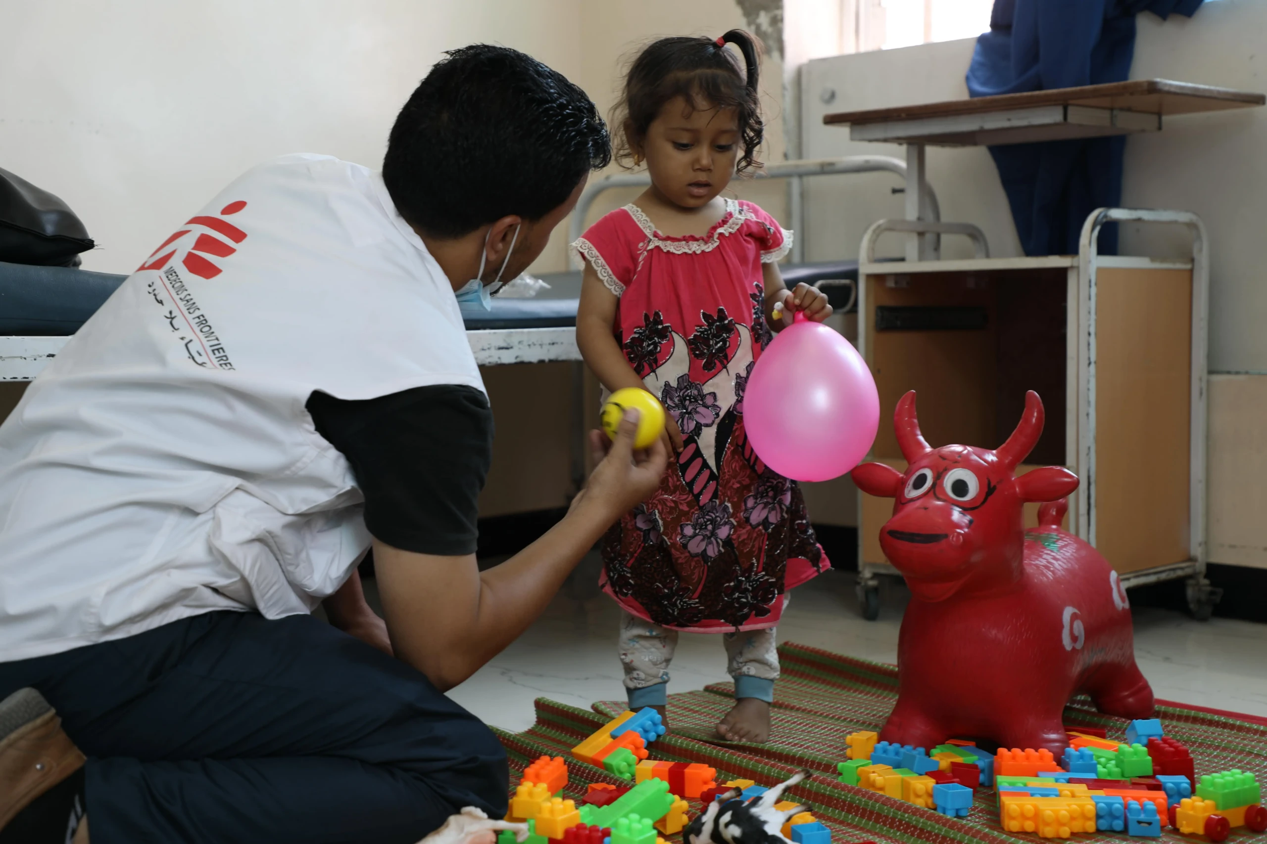 El consejero de salud mental Amin Al-Badri juega con Malak, de tres años, que está siendo tratada por hemólisis en el hospital materno-infantil de MSF en Houban.