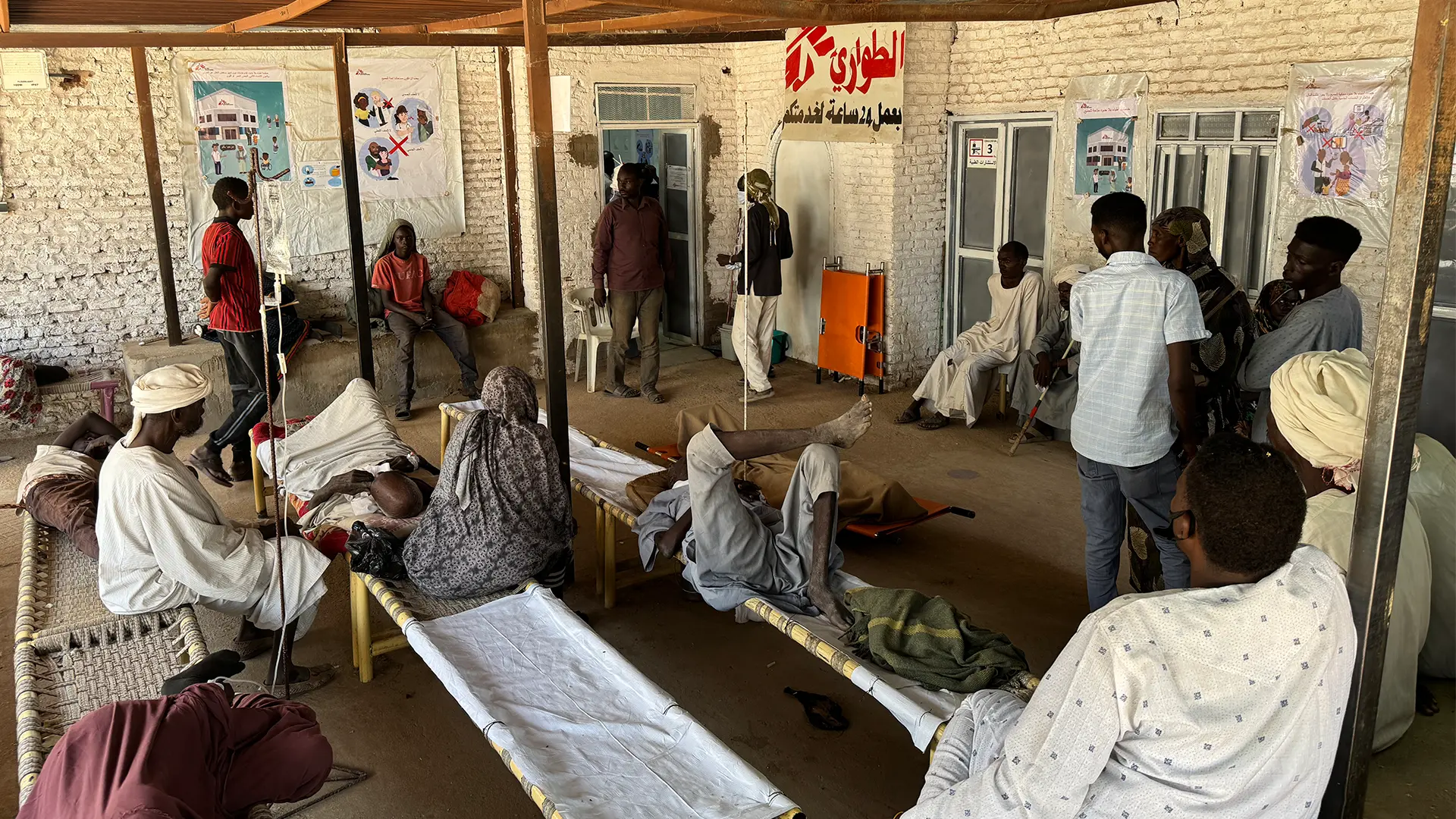 Pacientes esperan atención médica a la entrada de la unidad de urgencias del hospital de Tawila.
