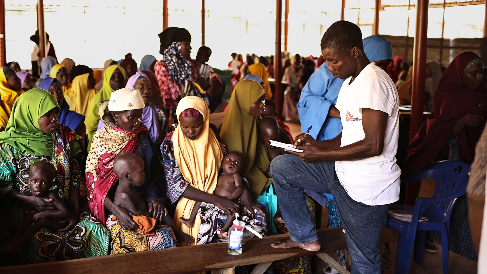 Un miembro del equipo de MSF recibe información de nuevos pacientes en el Centro de Alimentación Terapéutica Ambulatoria del Área de Gobierno Local de Jega, en el estado de Kebbi.