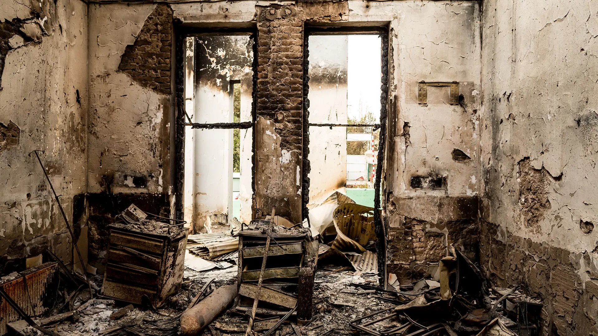 Cómodas y tanques de gas cubren el suelo en la entrada de emergencia en el centro del edificio, con vista hacia la puerta principal del hospital.