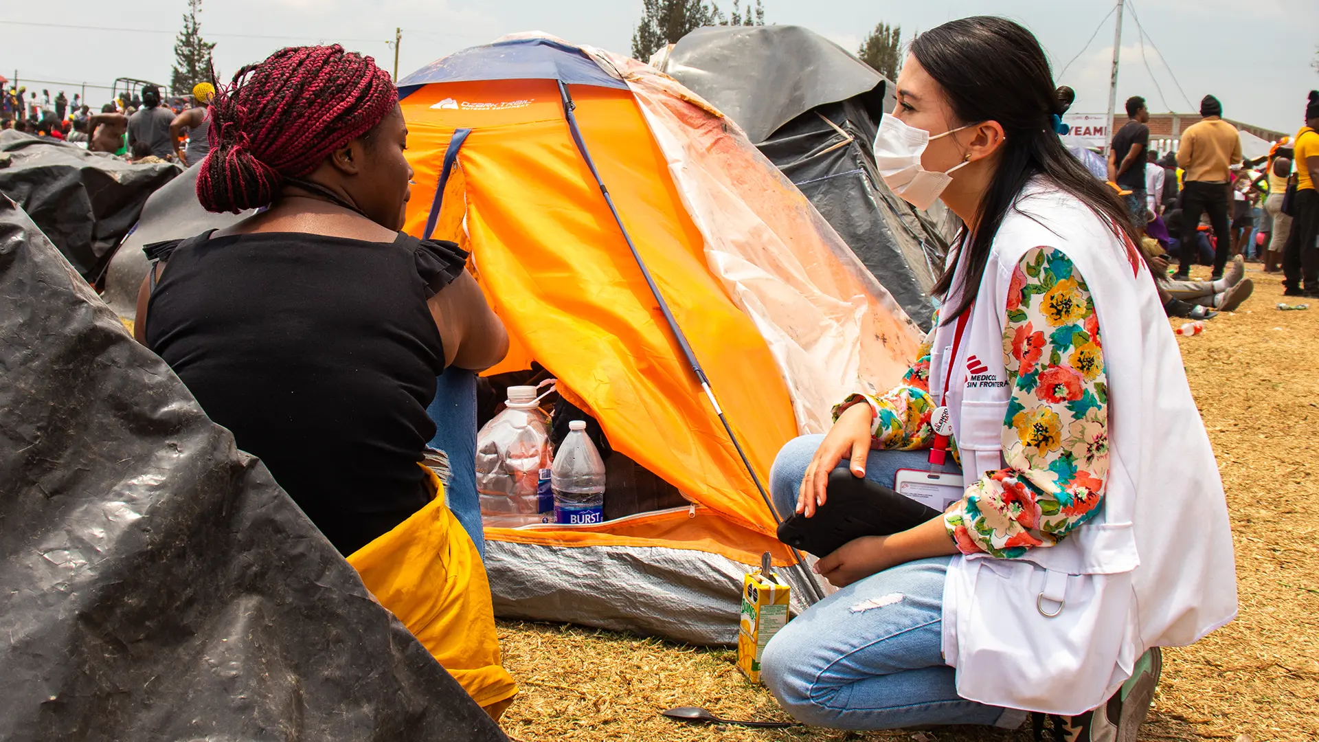 Una médica de MSF habla con una mujer haitiana alojada en el campamento informal de personas migrantes en el parque Tláhuac, Ciudad de México, 2023.