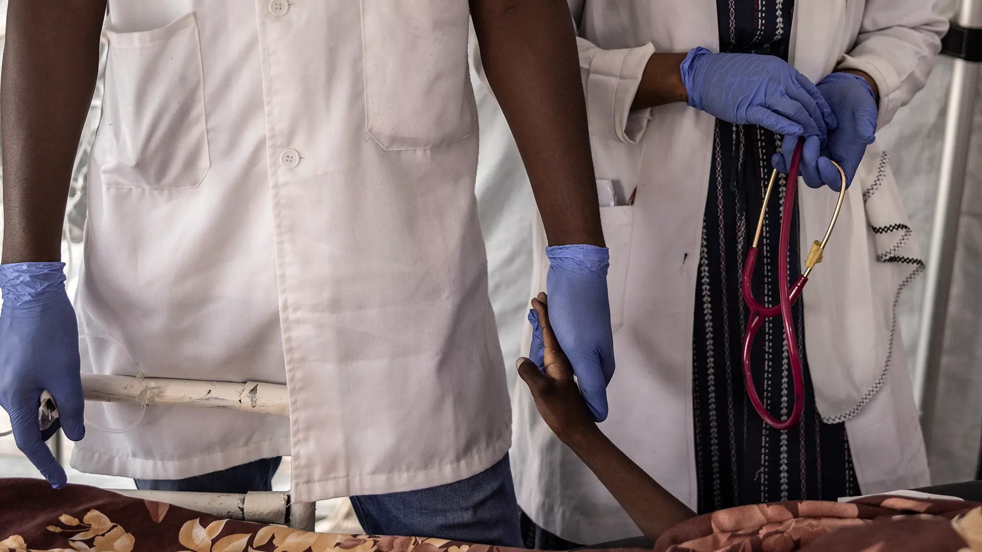 Una enfermera sostiene la mano de Haidara Atim, de 10 años, que sufría de bronquitis traqueal y shock séptico, después de que muriera cuando los médicos no pudieron resucitarlo en la unidad de cuidados intensivos del Hospital MSF en Metche, en el este de Chad, el 7 de agosto de 2024.