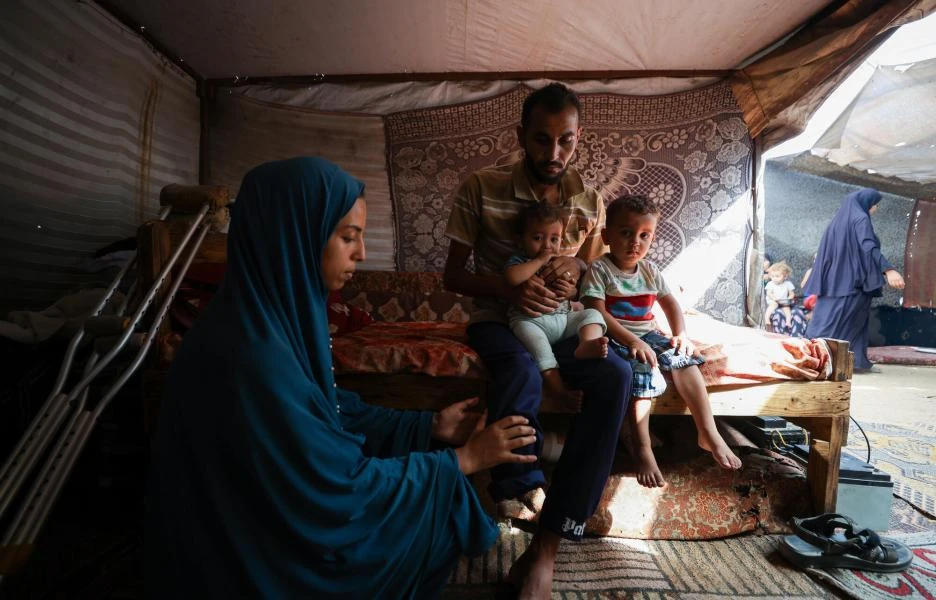 Bassel con su familia en la tienda de campaña en la que viven en Al Mawasi, Jan Yunis.