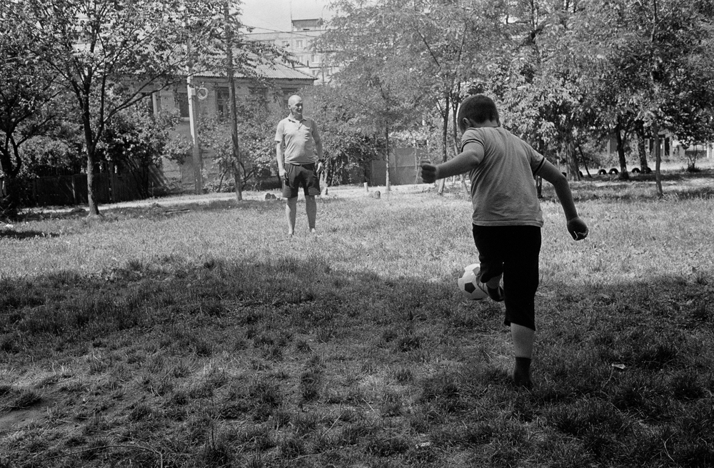 Padre e hijo juegan al fútbol junto a un albergue para poblaciones desplazadas en Dnipró, Ucrania