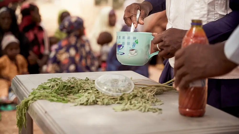 Maryam Muhammad, sostiene una taza durante una demostración de la receta de Tom Brown en Kebbi, Nigeria.