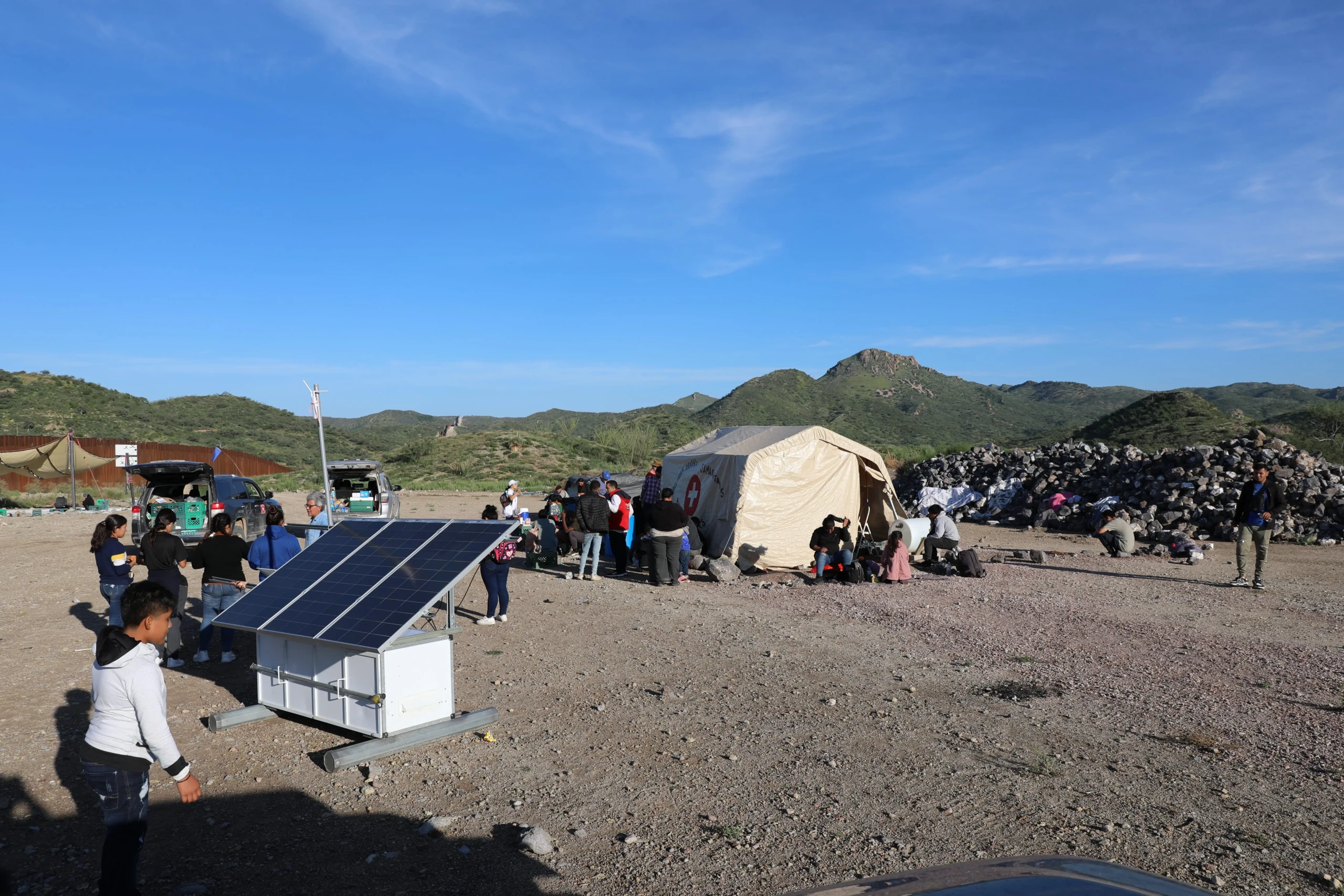 Un grupo de solicitantes de asilo de varios países esperan en el campamento End of the Wall a que la Patrulla Fronteriza los recoja. 