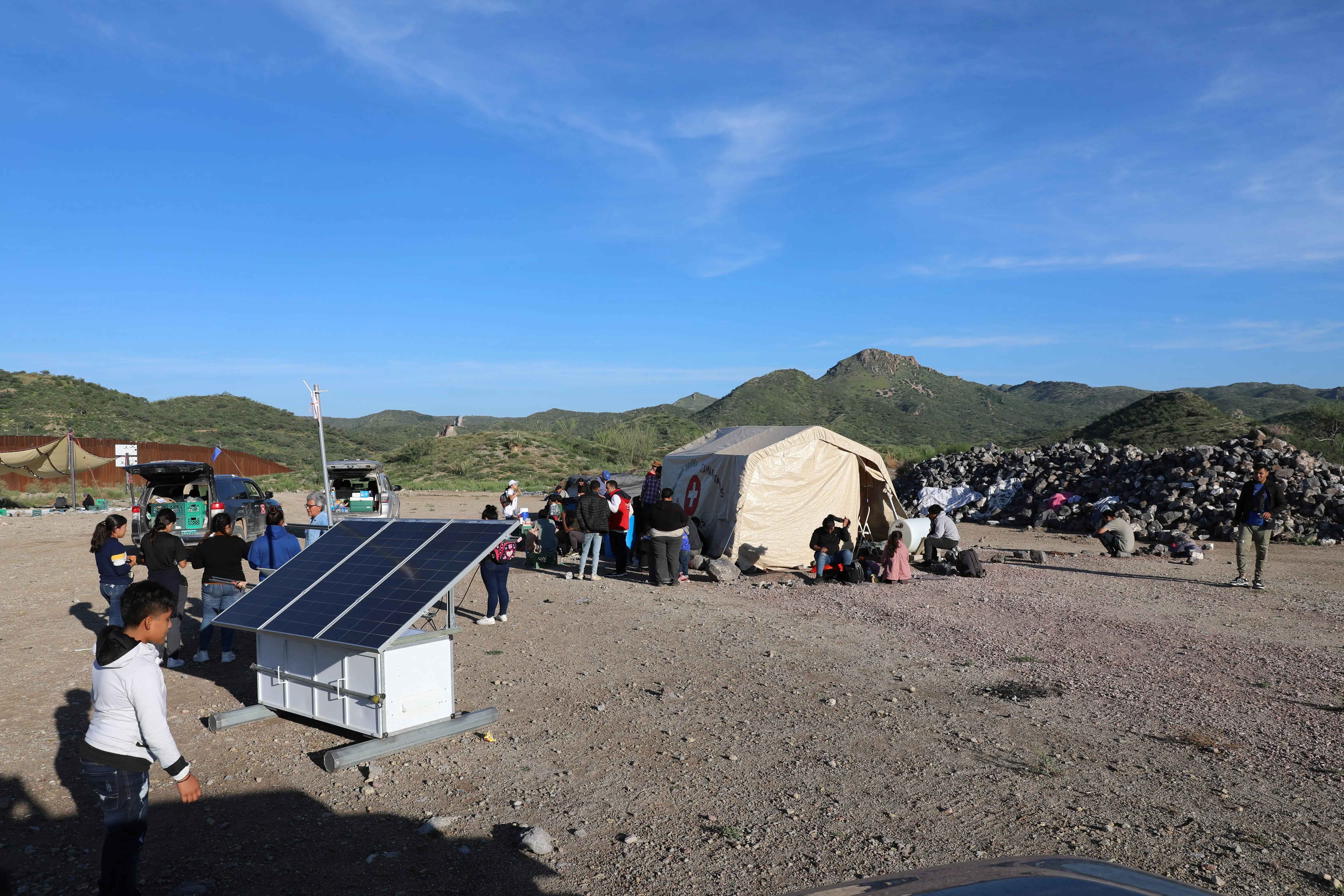 Un grupo de solicitantes de asilo de varios países esperan en el campamento End of the Wall a que la Patrulla Fronteriza los recoja. 