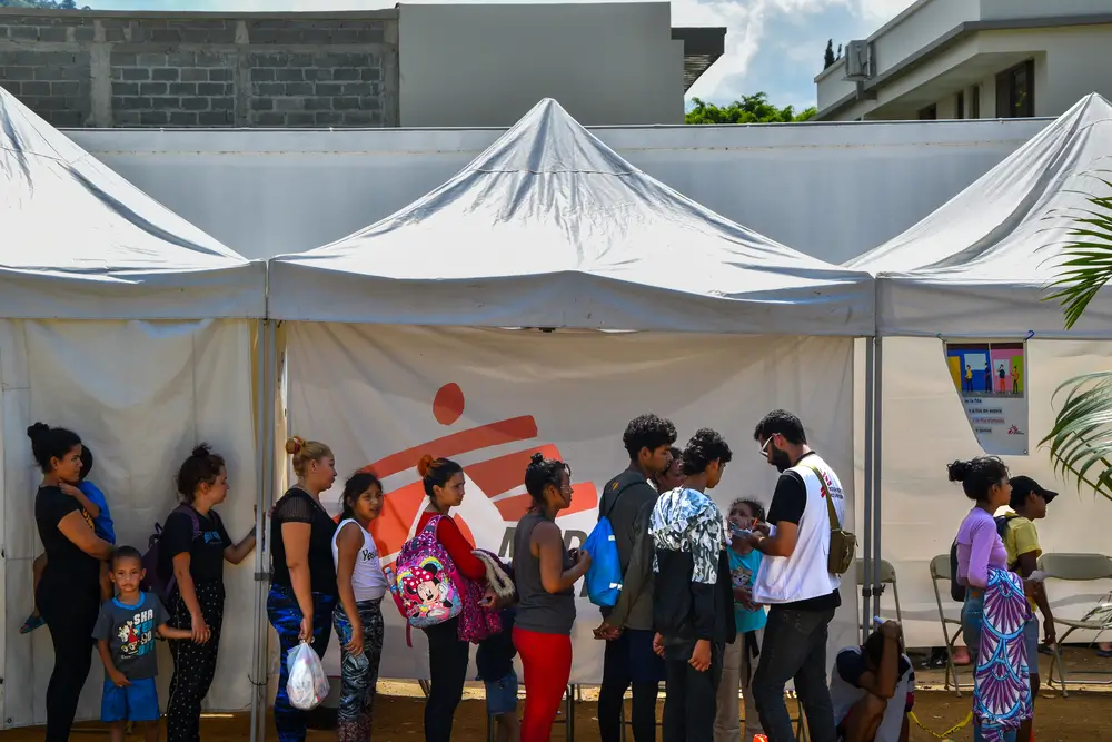 Personas migrantes hacen una fila para acceder a atención médica o acompañamiento psicológico en la clínica móvil de MSF en Danlí.