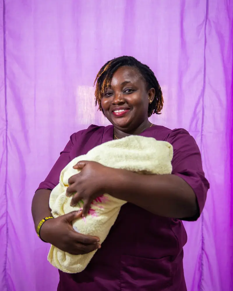 Rhoda Awanyah, supervisora de parteras de MSF en el CEMONC de Kushari, sostiene a un bebé recién nacido que está de camino a casa.