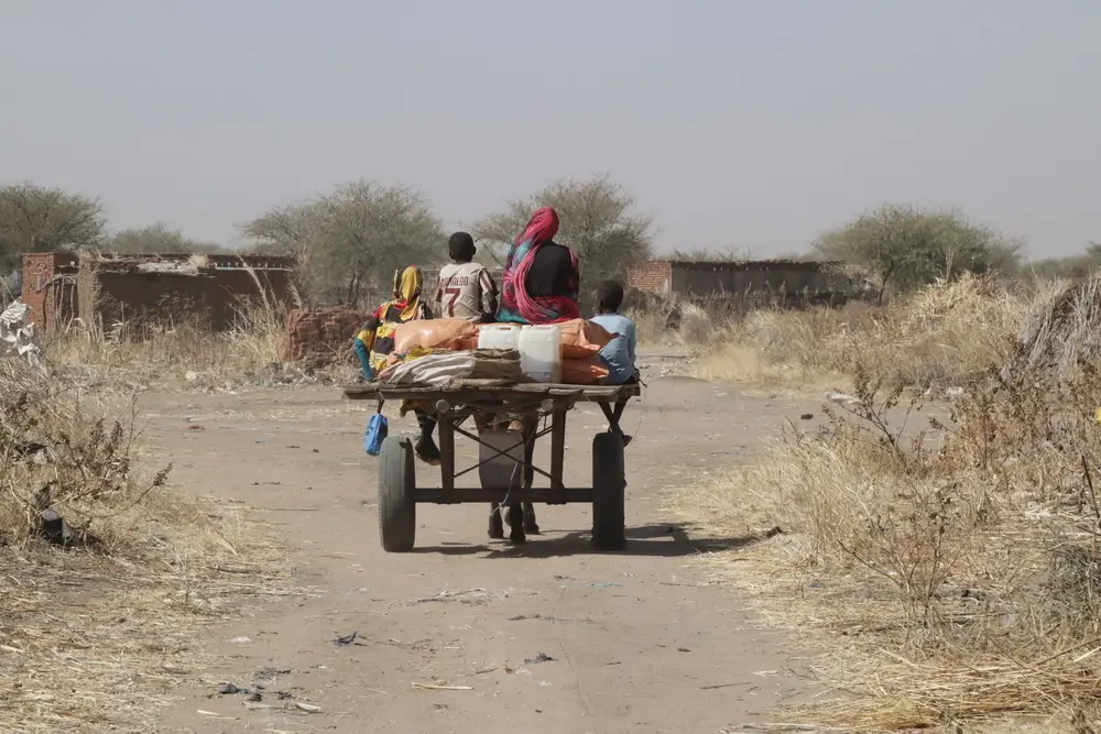 Una familia regresa a casa tras recibir canastas de alimentos en una distribución en Darfur Sur. Sudán, enero de 2025.