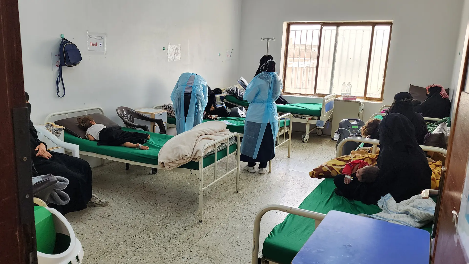Un médico de MSF examina a pacientes en la sala de aislamiento del hospital Al-Wahda, gobernación de Dhamar, Yemen, junio de 2025.
