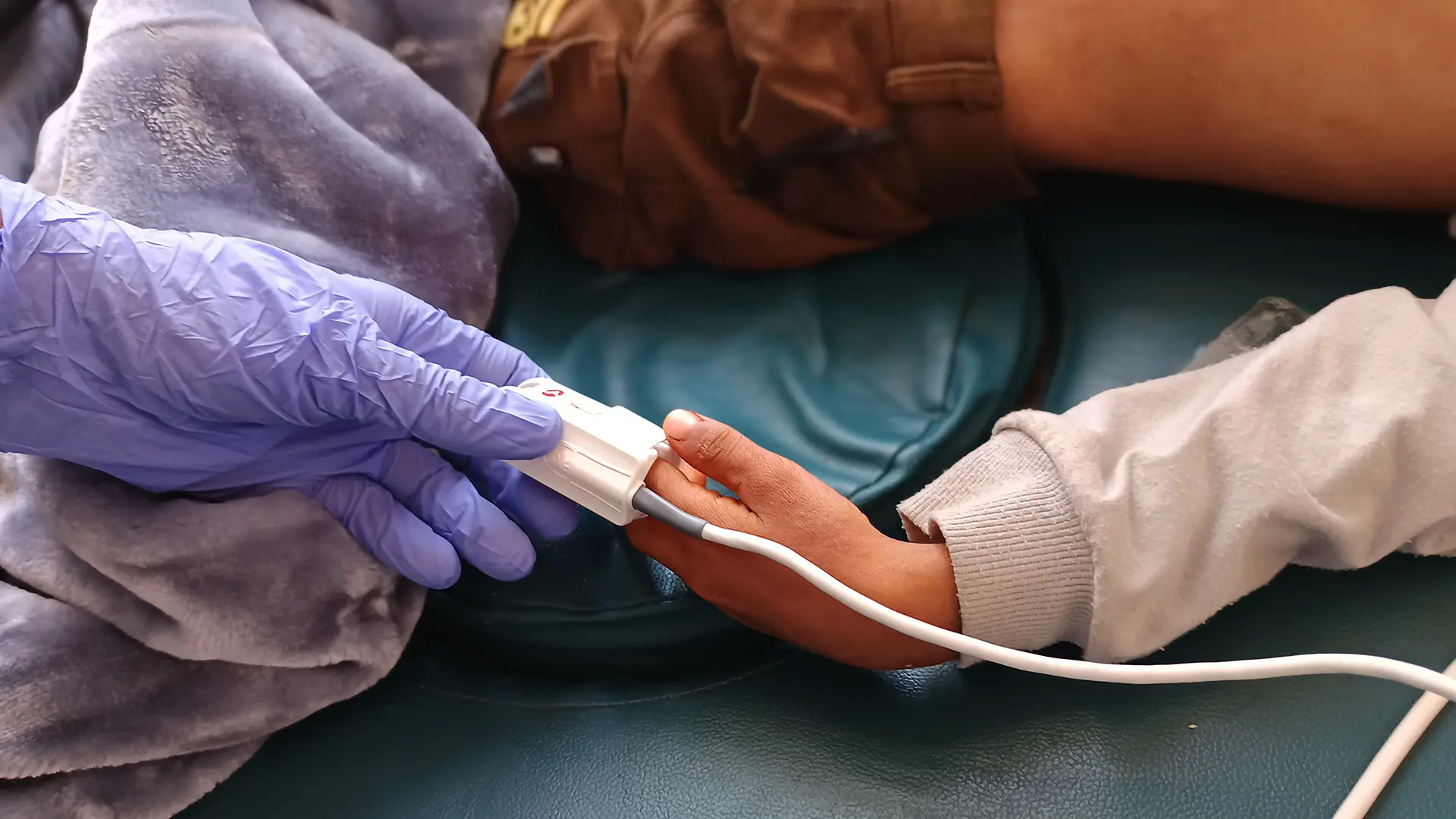 Una enfermera registra los signos vitales de un paciente que se encuentra en la sala de aislamiento del hospital Al-Wahda, gobernación de Dhamar, Yemen, mayo de 2025.