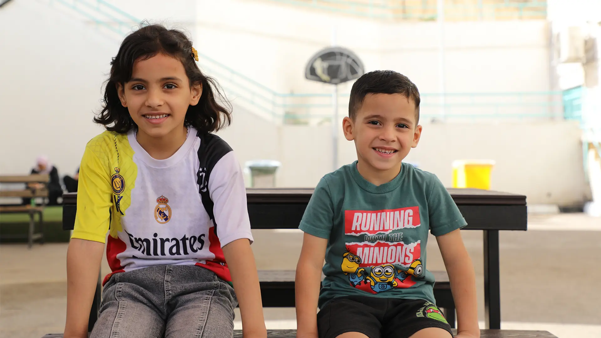 Omar está sentado con su hermana en el patio del hospital de cirugía reconstructiva de Amán, Jordania.