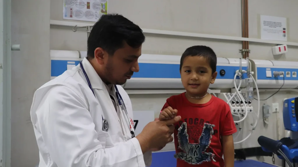 Yusuf habla con su médico mientras recibe tratamiento en la unidad de cuidados intensivos pediátricos de MSF en el Hospital Regional Abo Ali Sina, en Mazar i Sharif en elnorte de Afganistán.