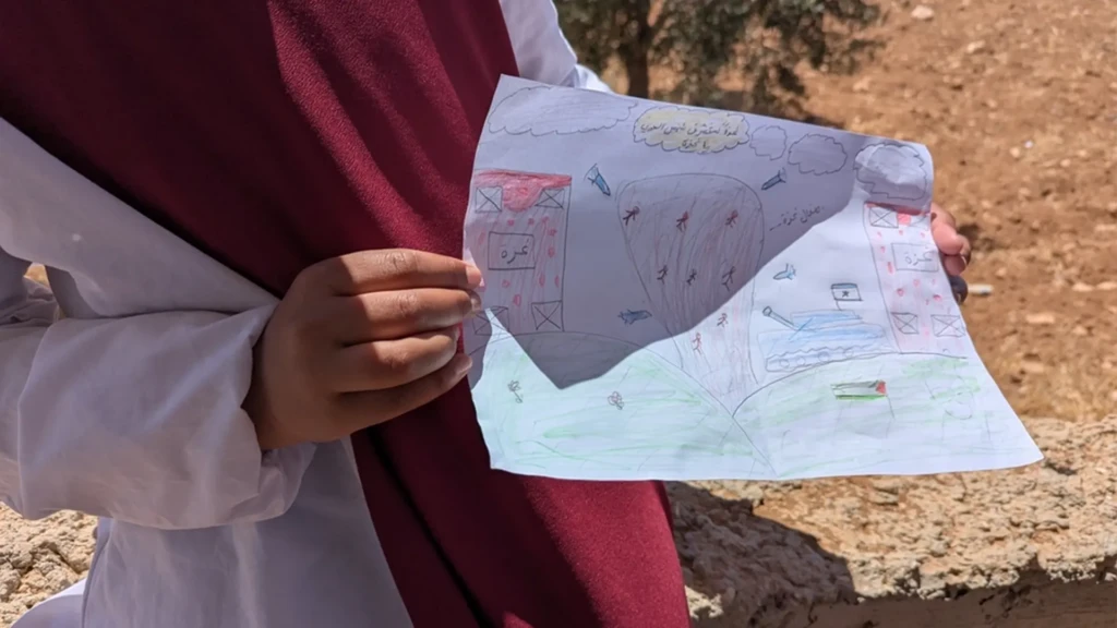 Reema*, 13 años, Masafer Yatta, Cisjordania, Palestina, muestra un dibujo del día que demolieron su casa.