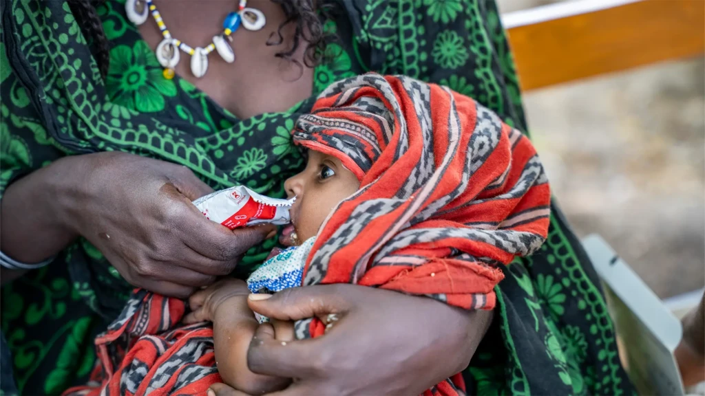 Igahale, de 13 meses, come un sobre de alimento terapéutico proporcionado por el equipo de divulgación de MSF en el centro de salud Magenta.