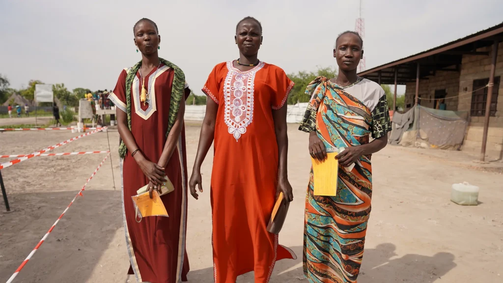 Tres mujeres llevan sus registros de vacunación después de haber recibido su primera dosis de la vacuna contra la hepatitis E en diciembre de 2023 en Hai Matar, estado de Jonglei. 