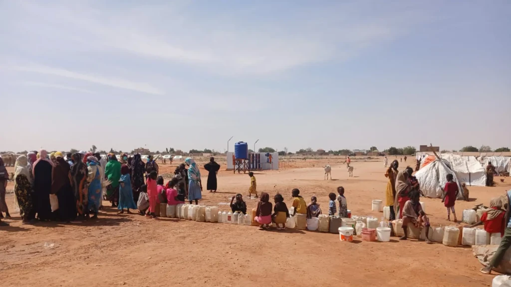 Personas desplazadas hacen fila para obtener agua potable en Al Mina Al Muwahad, el campo de desplazados más grande cerca de la ciudad de El Obeid.