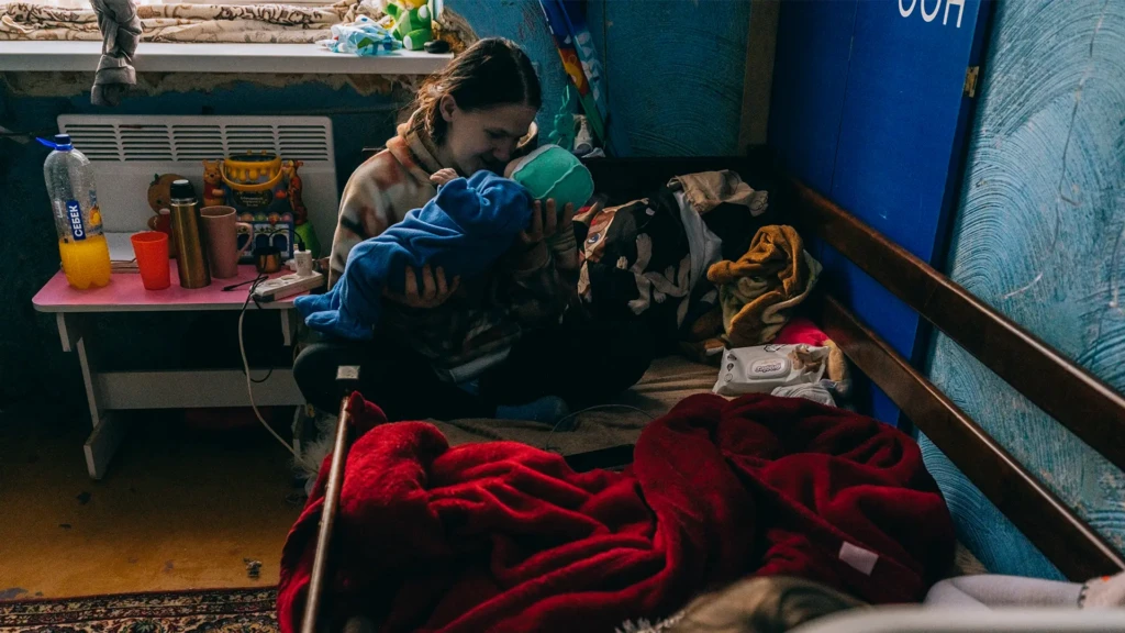 Kateryna Murashkina sostiene a su bebé de dos meses, Damir. Se encuentran en un refugio en Dnipro, una antigua institución científica. Ucrania, febrero de 2026. 