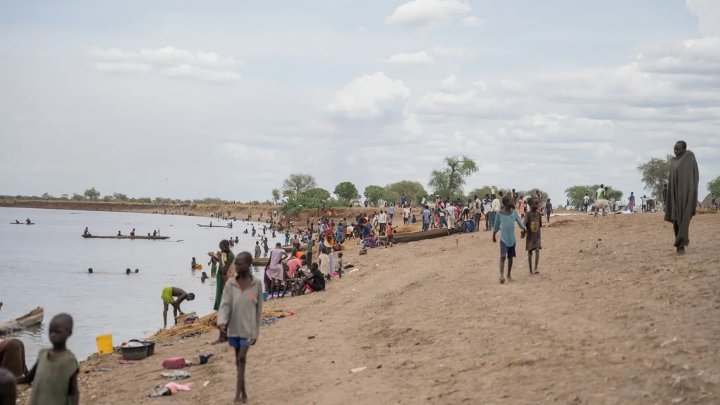 La gente realiza actividades diarias a lo largo de la orilla del río en Chuil, estado de Jonglei, Sudán del Sur, donde las familias desplazadas dependen del río para agua, lavarse y cocinar tras huir de la violencia.